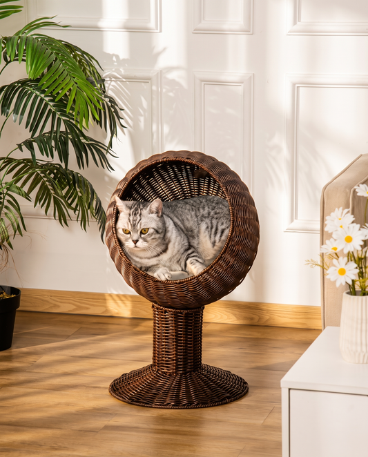 Elevated dark hand-woven egg pod cat bed featuring a white inner cushion on a rotatable pedestal base.